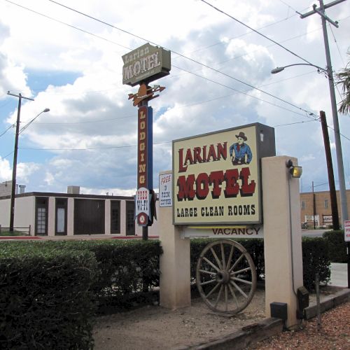 The image shows the Larian Motel with signs advertising large clean rooms, a western theme, and vacancy.
