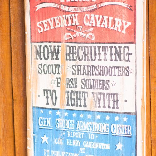 A vintage recruitment sign for the U.S. Army Seventh Cavalry, featuring Gen. George Armstrong Custer, seeking scouts and sharpshooters.